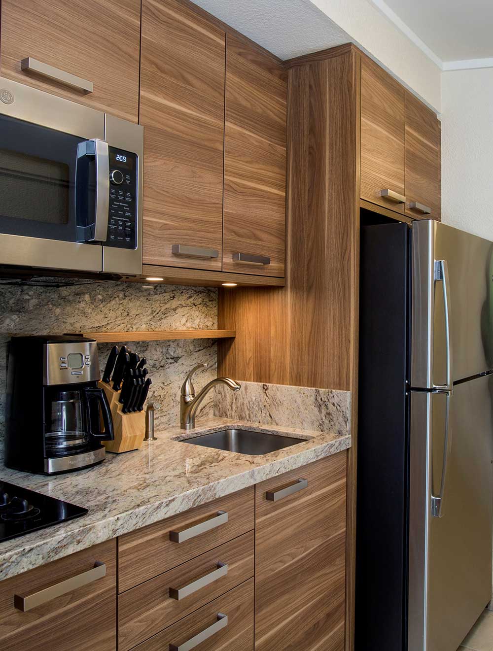 Compact kitchen with modern appliances and wood cabinetry