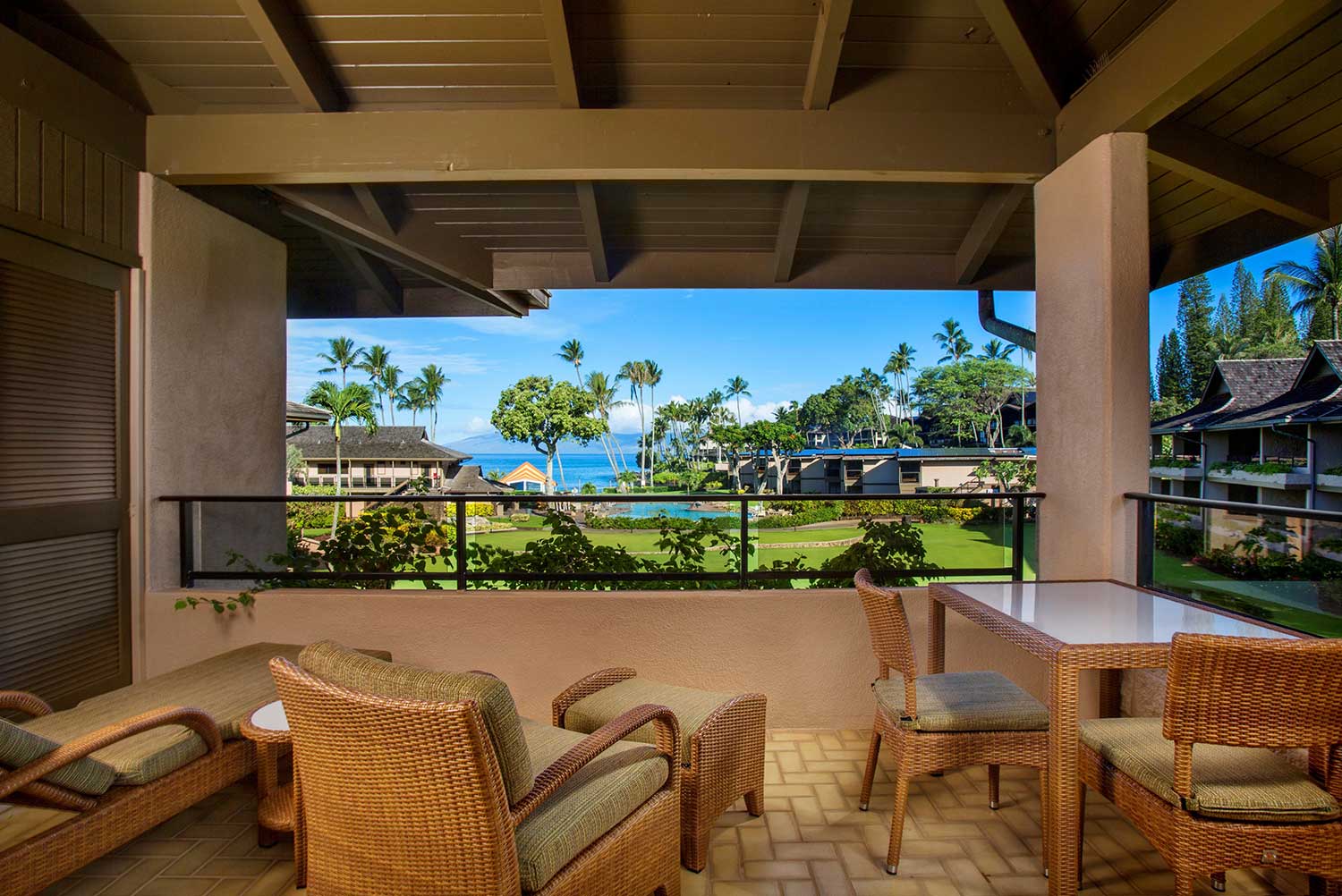 Ocean view lanai with seating overlooking tropical grounds and ocean